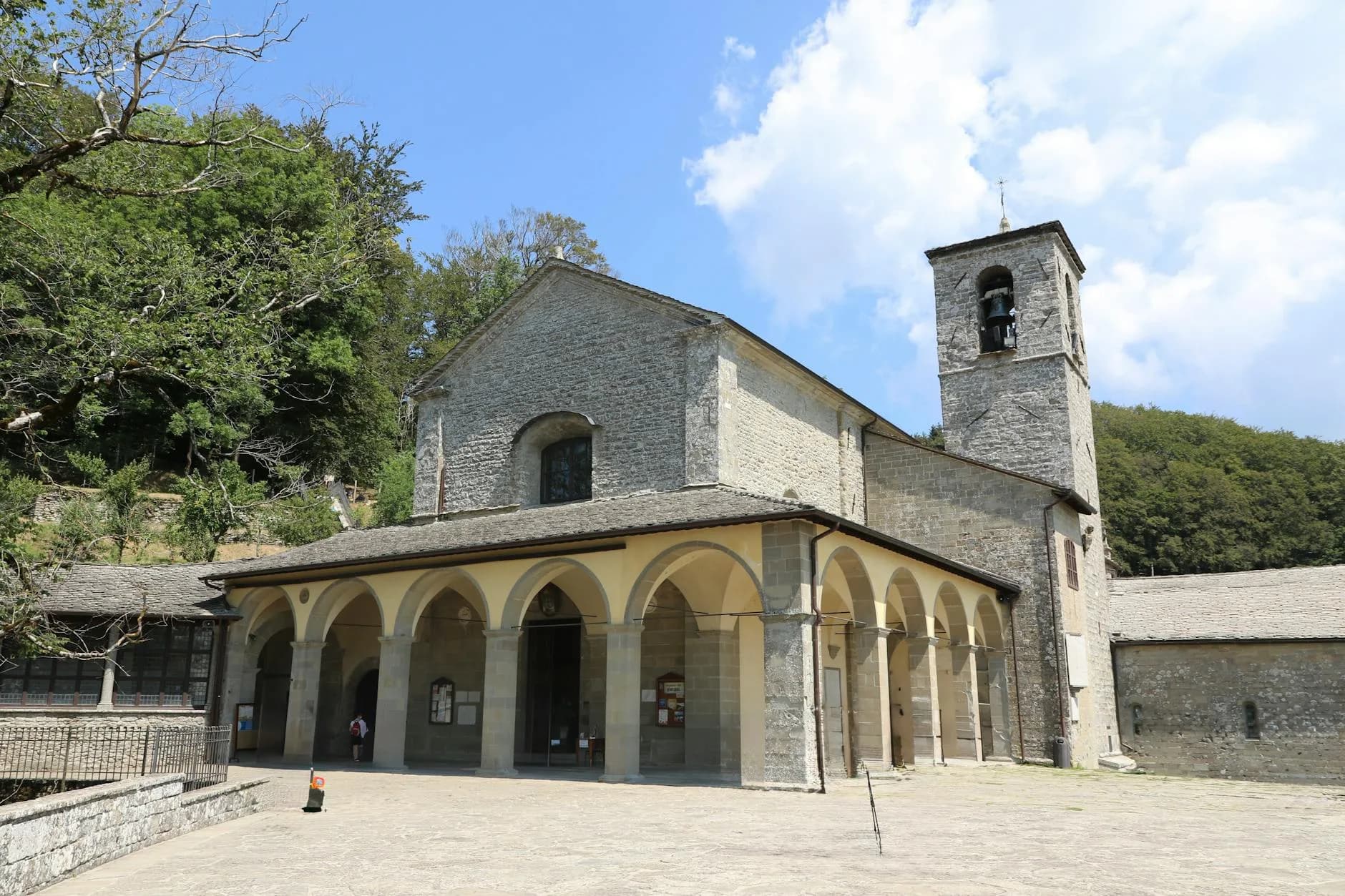 A picturesque view of an ancient stone building with a bell tower in Tuscany, Italy.